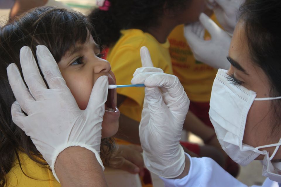 foto de uma dentista voluntária com uma criança do instituto
